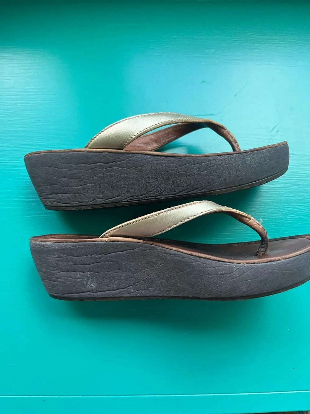 OluKai Wedge Flip Flop Sandals in Metallic Gold